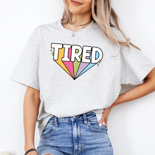 a woman wearing a t - shirt with the word tired printed on it