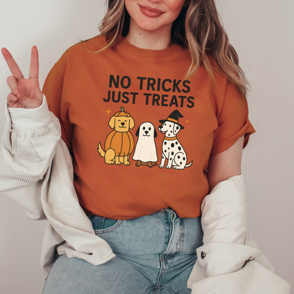 A woman wearing a brown t-shirt with a graphic design of three dogs and a ghost, along with the text "NO TRICKS JUST TREATS".