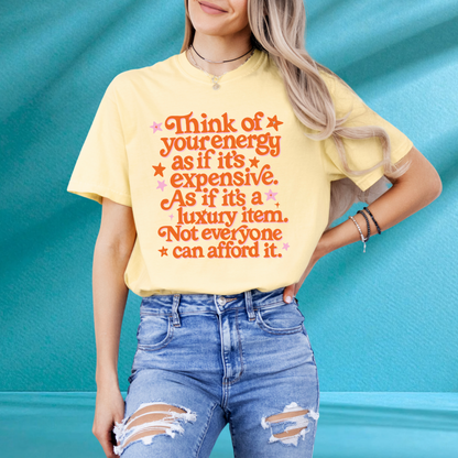 A woman wearing a yellow t-shirt with a printed message and ripped jeans stands against a blue background.