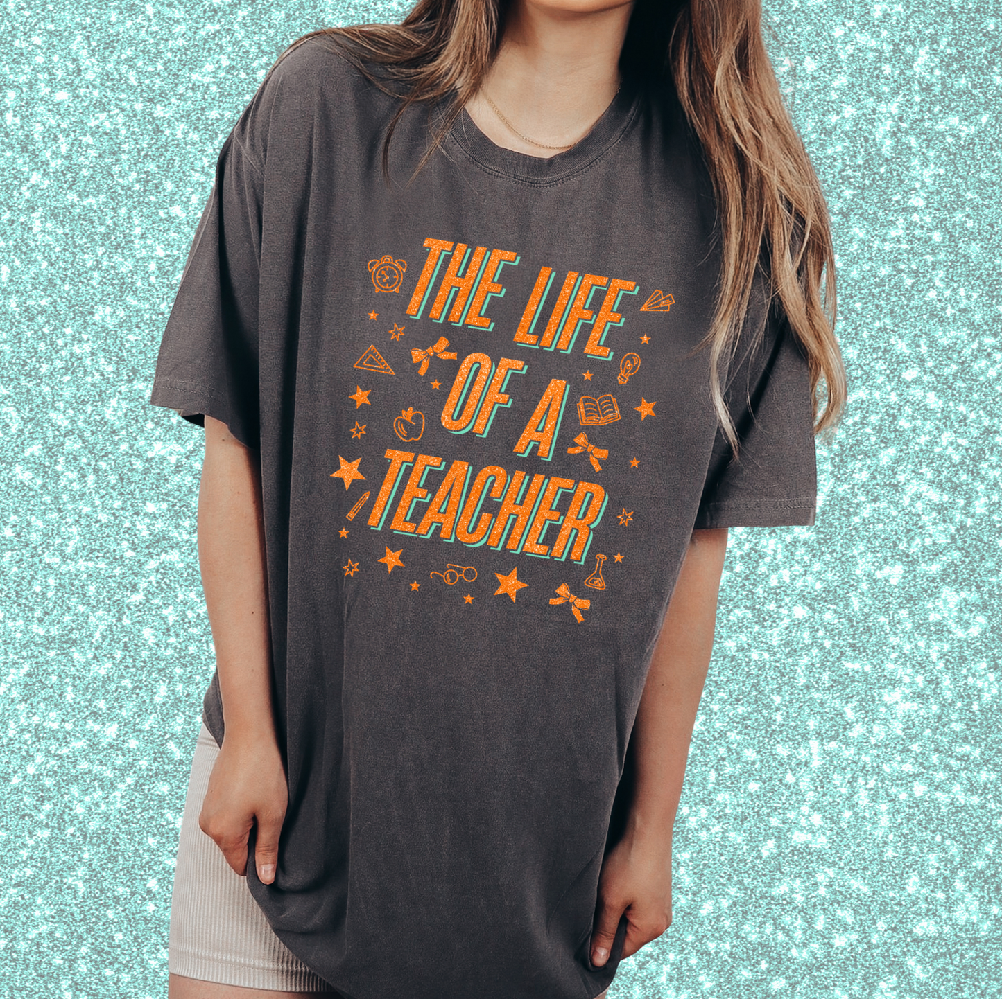 A person wearing a gray t-shirt with the text "THE LIFE OF A TEACHER" printed on it.