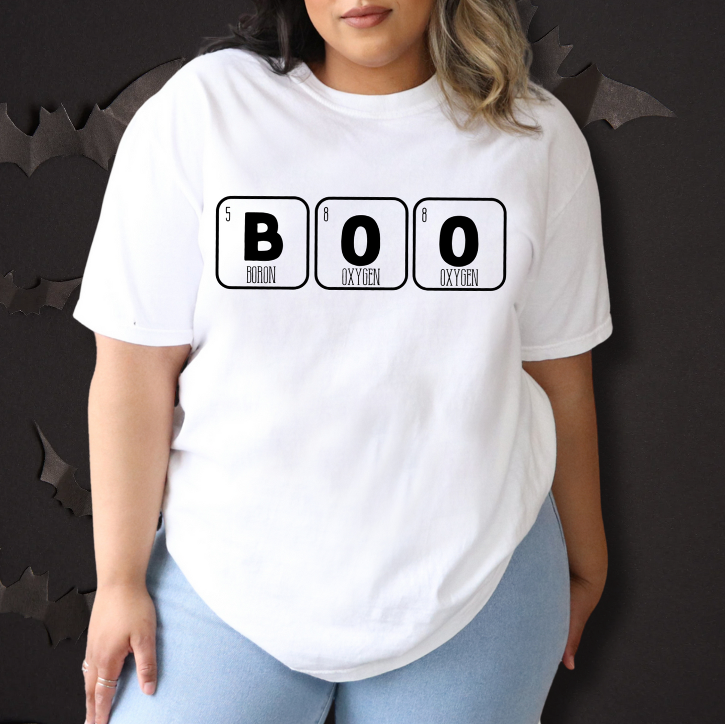 A person wearing a white t-shirt with the text "BOO" printed on it, along with the chemical symbols for oxygen and carbon.