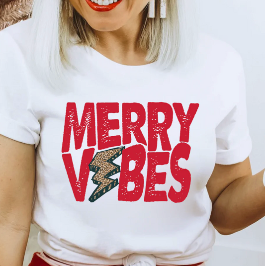 A woman wearing a white t-shirt with the text "MERRY VIBES" printed on it.